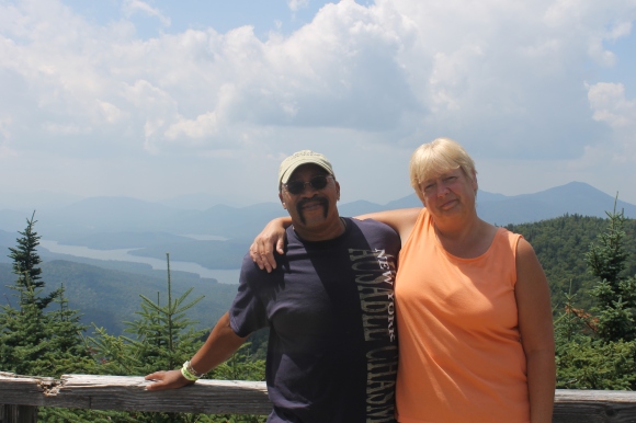 Image of the author's black father and white mother smiling on a warm summer day at the summit of whiteface mountain. 
